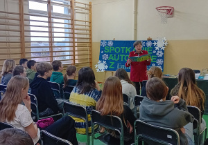 Pani Emilia Tesz czyta uczniom klas siódmych wiersz ze swojej książki