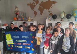 Laureaci z klas 7- 8 z dyplomami oraz pozostali uczestnicy konkursu stoją w pracowni przyrodniczej.