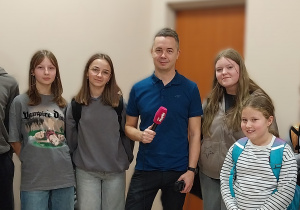 Uczniowie udzielający wywiadu z dziennikarzem radiowym.