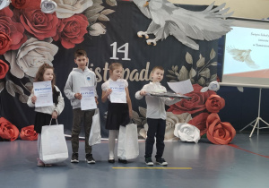 Nagrodzone dzieci w konkursie plastycznym stoją z dyplomami i nagrodami.