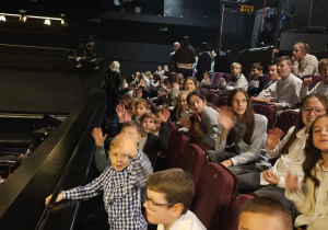 Uczniowie siedzą na widowni w teatrze.
