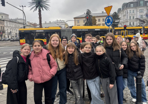 Piątoklasiści stoją przy jednej z ulic w Warszawie.