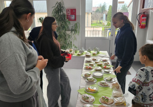Uczniowie oglądają kanapki przed zakupem.