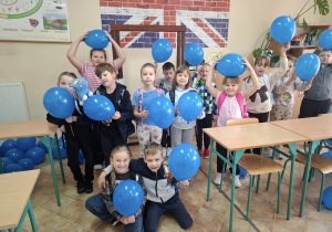 Uczniowie klasy IIb trzymają niebieskie balony.