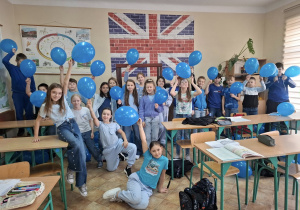 Uczniowie klasy IVb stoją z niebieskimi balonami.