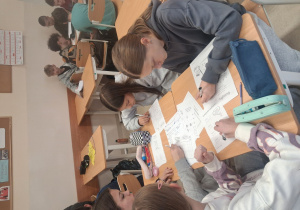 Uczniowie rozwiązują rebusy w Dniu Tabliczki Mnożenia.