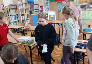 Dzieci ustawiają buty- wróżba andrzejkowa.