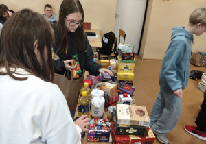 Dziewczynki segregują przyniesione produkty.