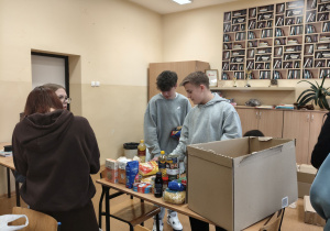 Chłopcy pakują produkty do pudełka.