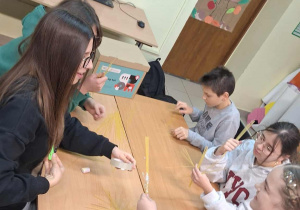 Uczniowie tworzą konstrukcje z makaronu.