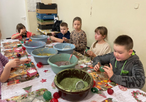 Uczniowie ozdabiają bombki brokatem