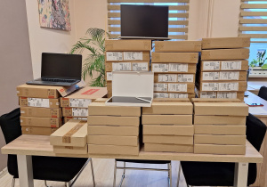 Pozyskany sprzęt komputerowy leży zapakowany na stole w gabinecie Pani Dyrektor.