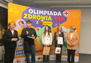 Laureaci olimpiady stoją z nagrodami.