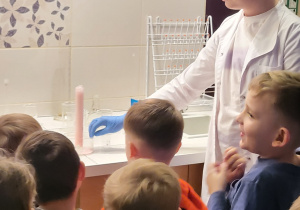 Uczeń klasy VIIIb wykonuje eksperymenty przed dziećmi.