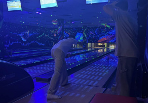 Chłopcy stoją na torze, jeden rzuca kulą.