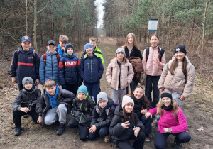 Uczniowie klasy Va na ścieżce w lesie.