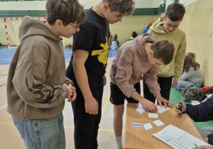 Chłopcy rozwiązują zadanie wiedzowe na czas.