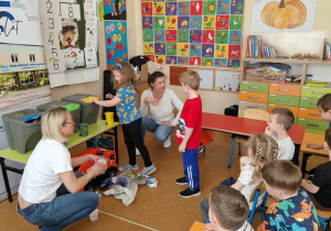 Panie uczą dzieci segregowania odpadków.