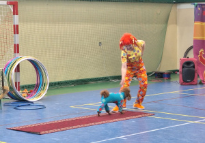 Klaun pokazuje sztuczki z psem.