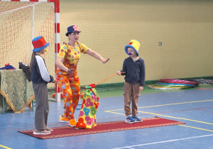 Uczniowie pomagają klaunowi w wykonaniu czarodziejskich sztuczek.