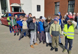 Przedszkolaki stoją przed budynkiem PCAS.