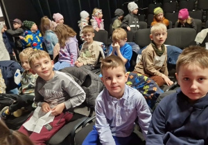 Dzieci z grupy "0" siedzą na krzesłach na widowni.