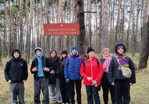 Uczniowie stoją w lesie spalskim.