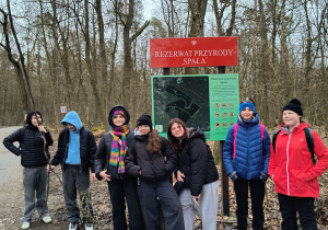 Uczniowie stoją przy tabliczce rezerwat przyrody " Spała".