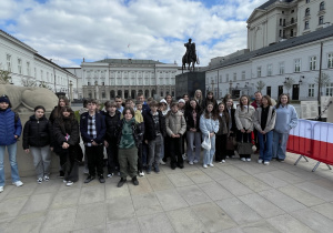 Uczniowie stoją przed Pałacem Prezydenckim.