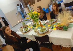 Dziewczynki z drużyny nr 2 siedzą przy przygotowanym przez siebie stole.