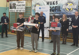 Chłopcy ze starszej grupy stoją z nagrodami i pucharem.