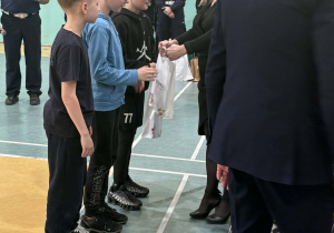 Chłopcy z młodszej grupy odbierają upominki za zajęcie 8 miejsca.