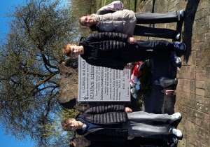 Uczniowie stoją przy pomniku poległych harcerzy.