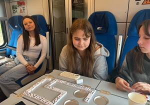 Dziewczynki grają w domino w czasie podróży pociągiem.