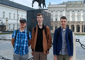 Chłopcy stoją przed Pałacem Prezydenckim.