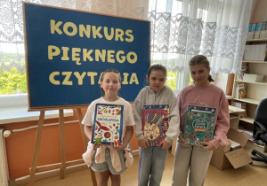 Laureatki Szkolnego Konkursu Pięknego Czytania stoją z nagrodami książkowymi.