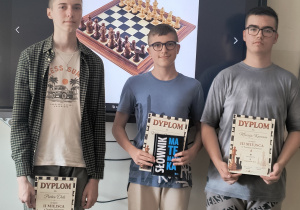 Szachowi mistrzowie w kategorii klas VII- VIII stoją z nagrodami i dyplomami.