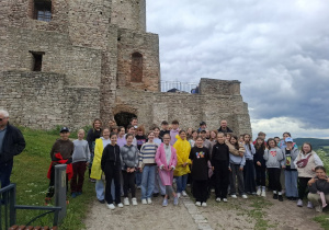 Czwartoklasiści stoją pod murami zamku w Chęcinach.