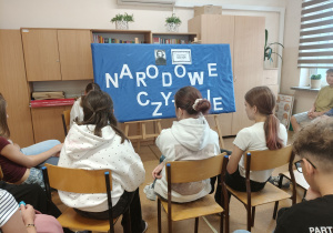 Uczniowie klasy VIIb siedzą i słuchają czytającej koleżanki.