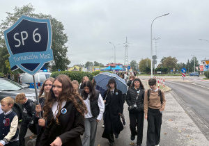 Uczniowie idą chodnikiem.