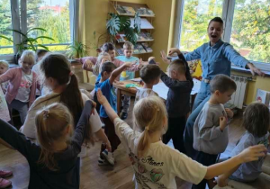 Dzieci wykonują ćwiczenia ruchowe.