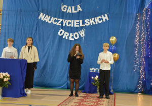 Uczennica odczytuje nazwisko zwycięzcy.