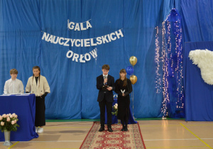 Uczeń czyta nazwisko nauczyciela, który zwyciężył.