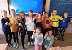 Dzieci z klasy IIIa prezentują przyniesione na lekcję jabłka