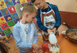 Chłopcy uczą się pracy z robotem kuchennym