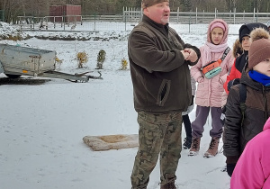 Pracownik ośrodka opowiada dzieciom o dokarmianiu zwierząt zimą
