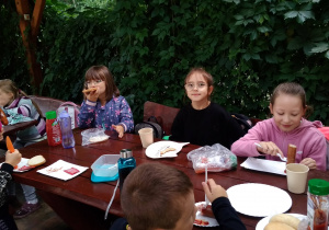 Dziewczynki jedzą kiełbaskę z grilla