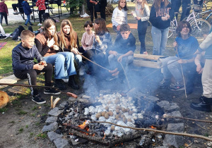Uczniowie pieką ziemniaki i kiełbaskę przy ognisku