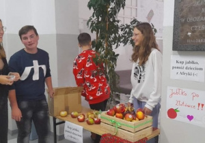 Uczniowie przy stoisku, gdzie można było kupić jabłko