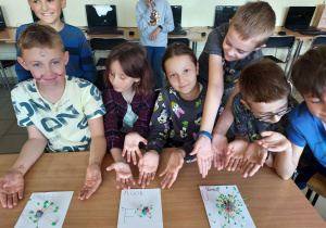 Dzieci prezentują wykonane przez siebie modele atomów